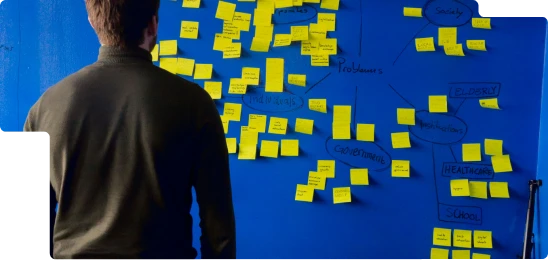 Entrepreneur organisant ses idées sur un mur de notes pour préparer son business plan et sa création d’entreprise en Normandie.